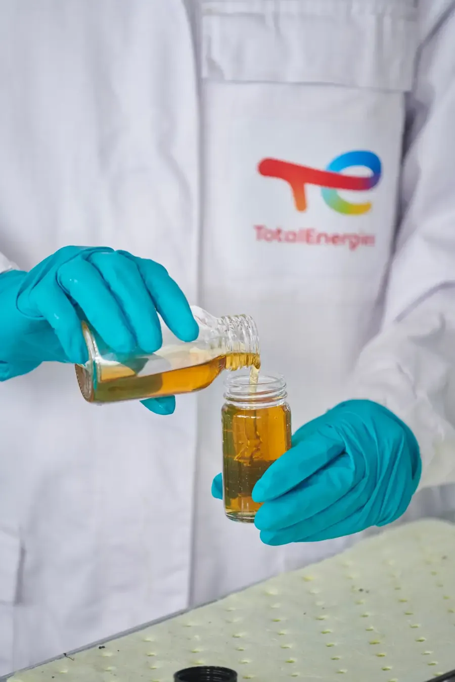 A TotalEnergies technician pouring an oil sample